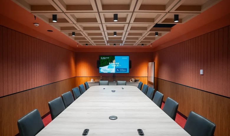 Acoustically treated executive boardroom with single-screen conferencing