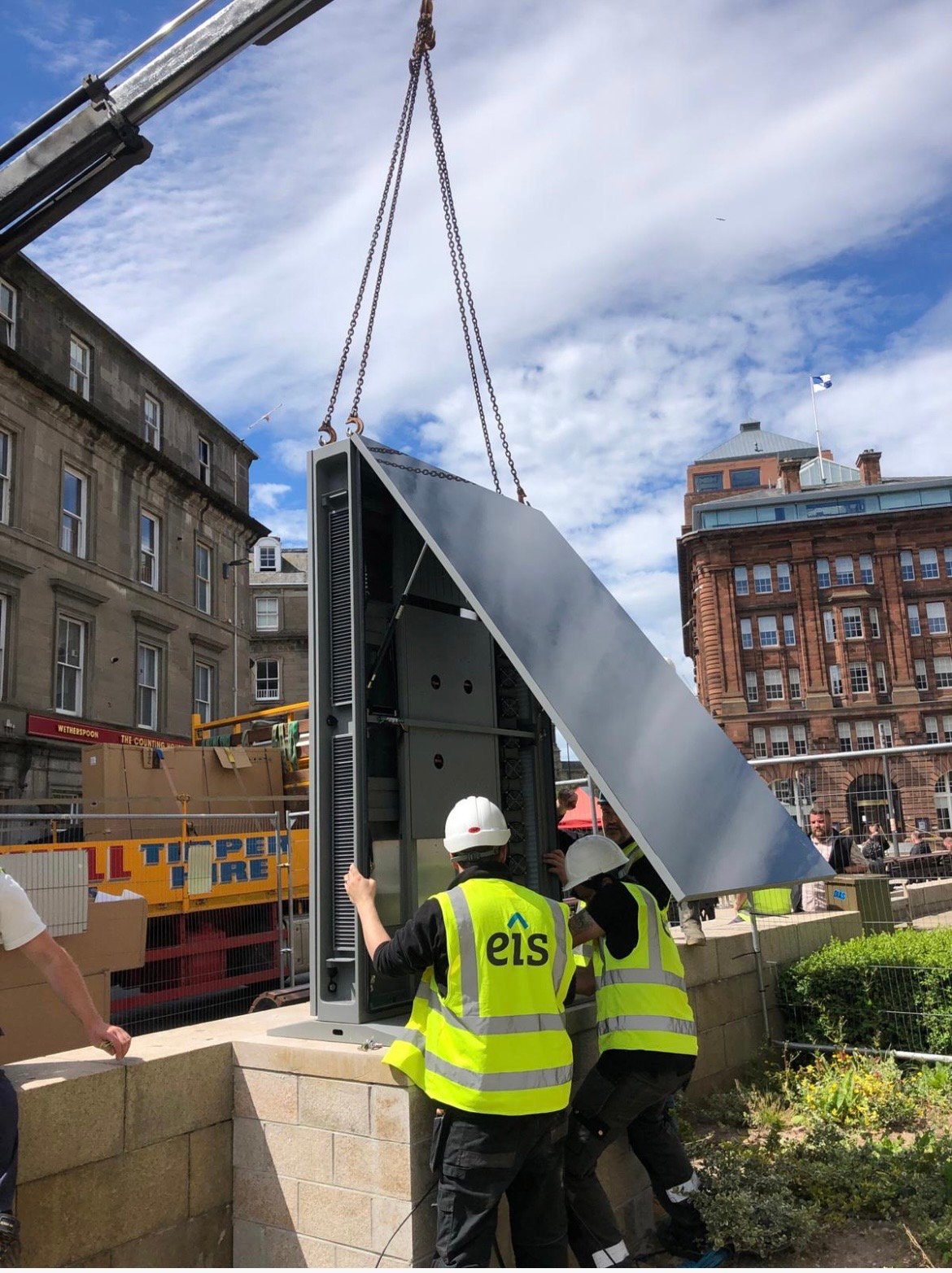 A crane lifting the outdoor LED kiosk into position on site in Dundee