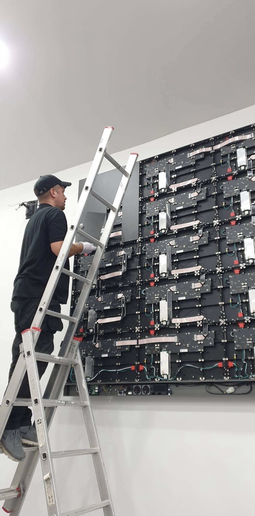 An engineer installing an LED panel as part of the video wall build at the SFRS Cambuslang auditorium