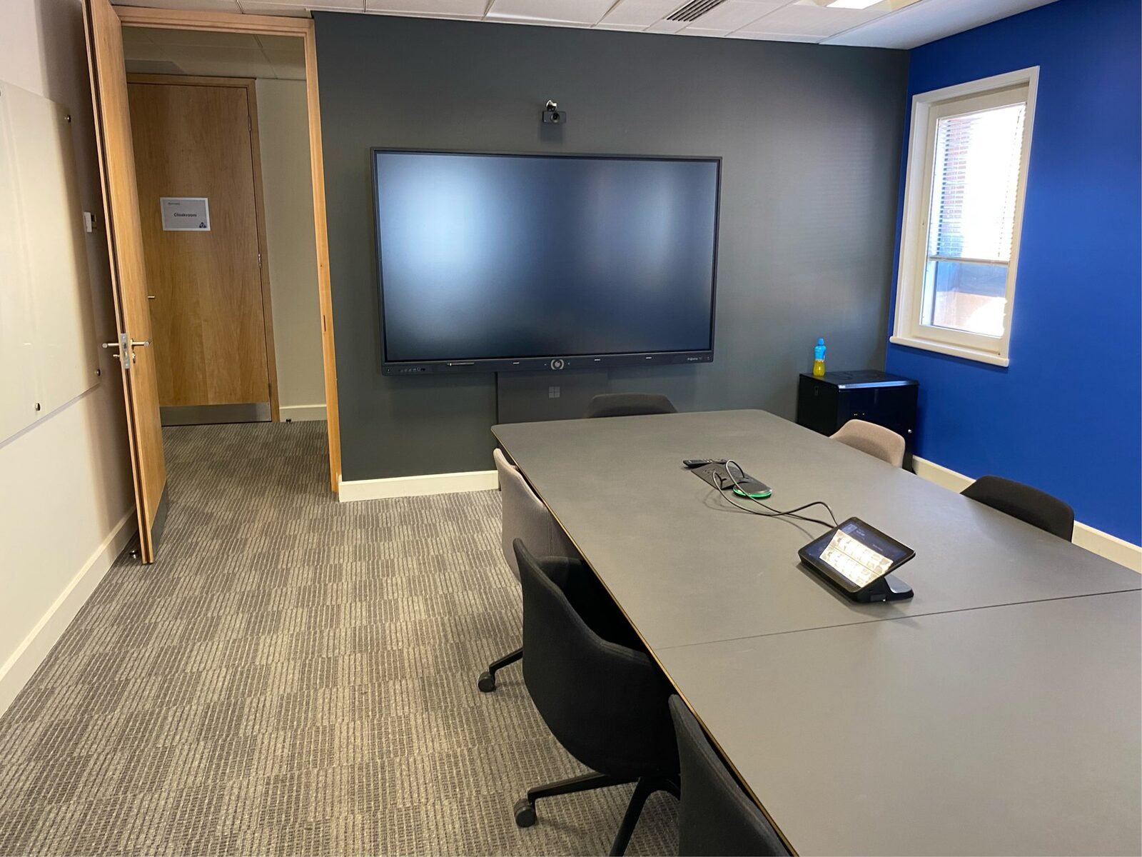 Boardroom AV Fit-Out: NTT DATA London boardroom viewed from the display wall, showing the long, narrow shape of the room that a single front-facing camera would struggle to cover